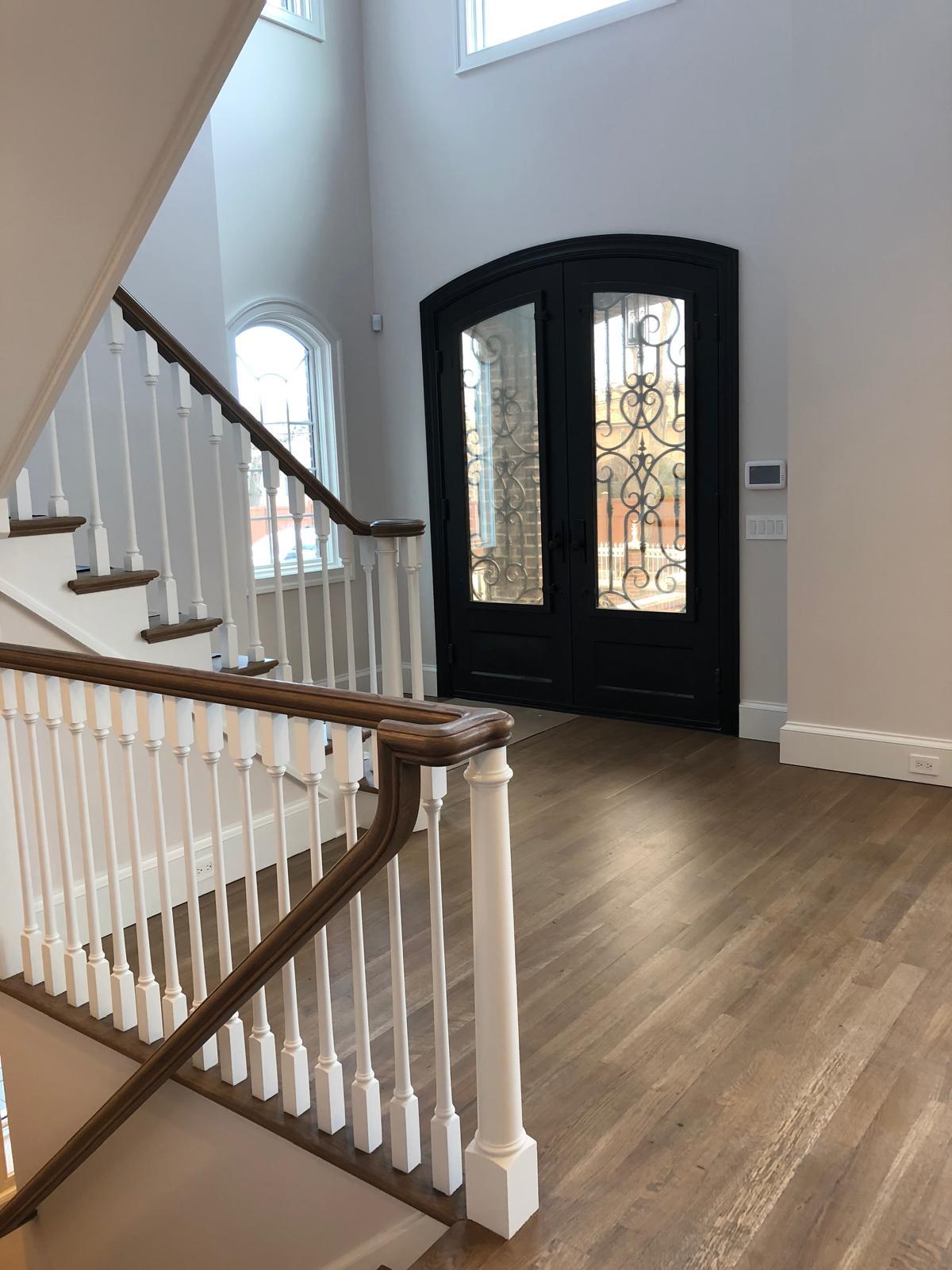 Two-story foyer with wrought-iron doors