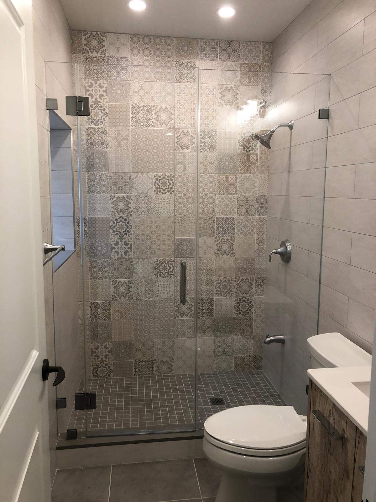 Frameless glass walk-in shower with patterned tile