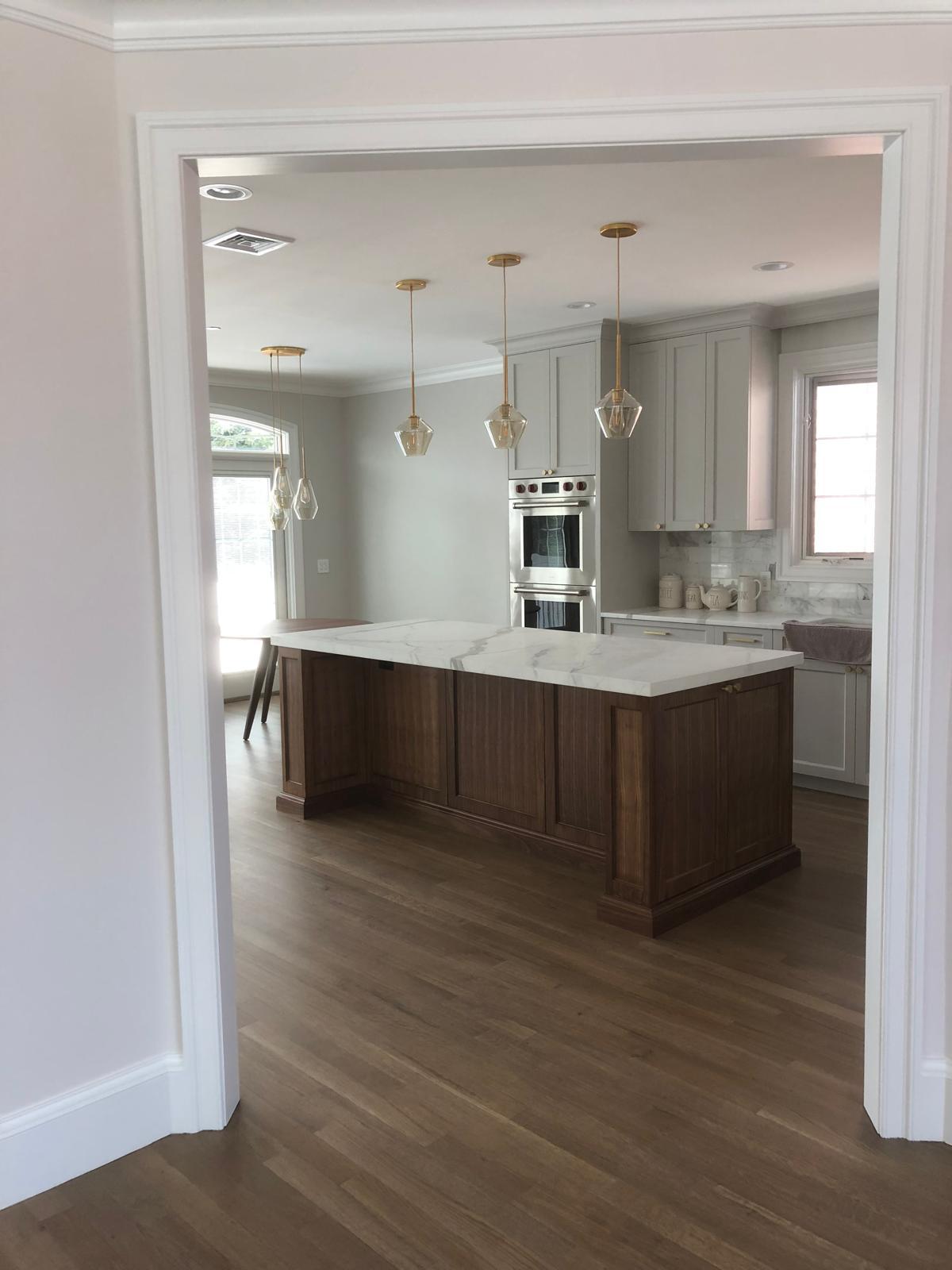 Open-concept kitchen viewed through a cased opening