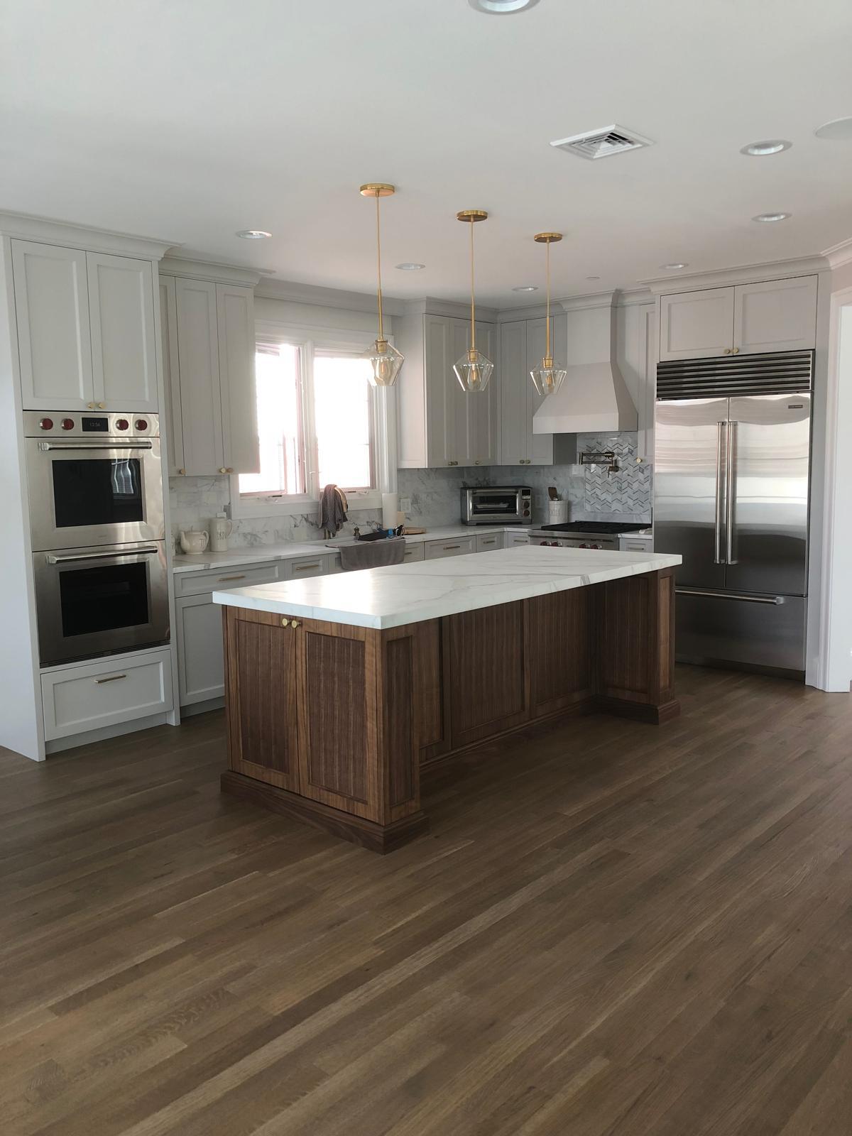 Renovated kitchen with walnut island, marble countertops, and stainless appliances