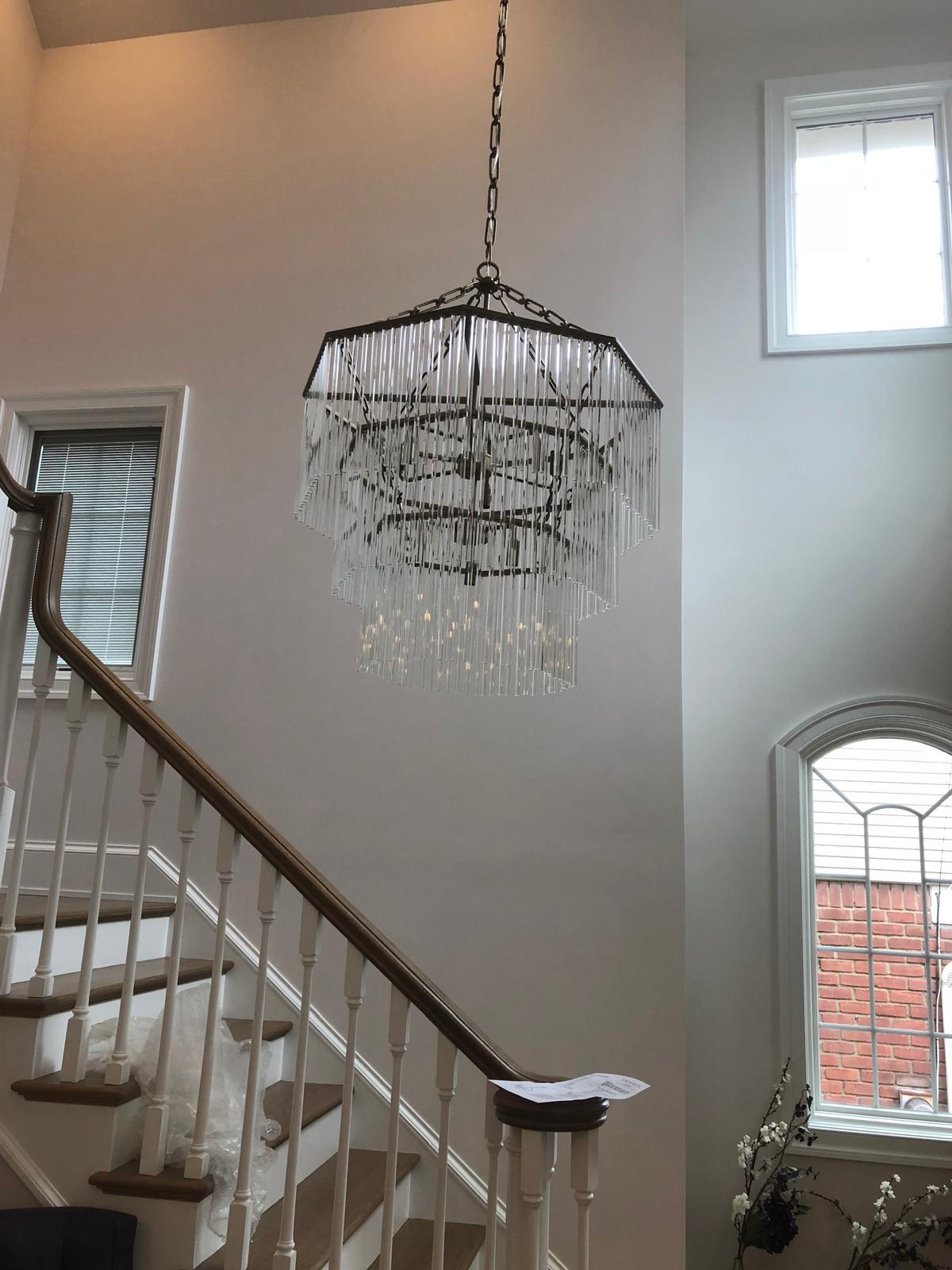 Multi-tier glass chandelier in a double-height stairwell